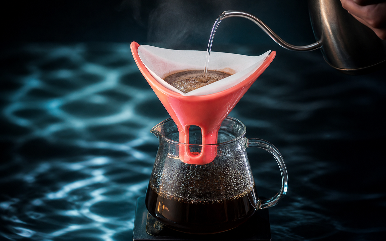 Water poured into a coral VYDRIPPER with coffee blooming inside